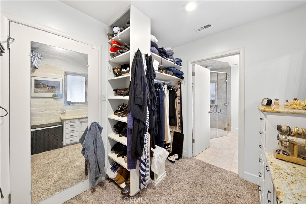 4872 N Arcade Fresno, CA 93704 - Photo 42 of 75 a view of walk in closet with clothes and shoes