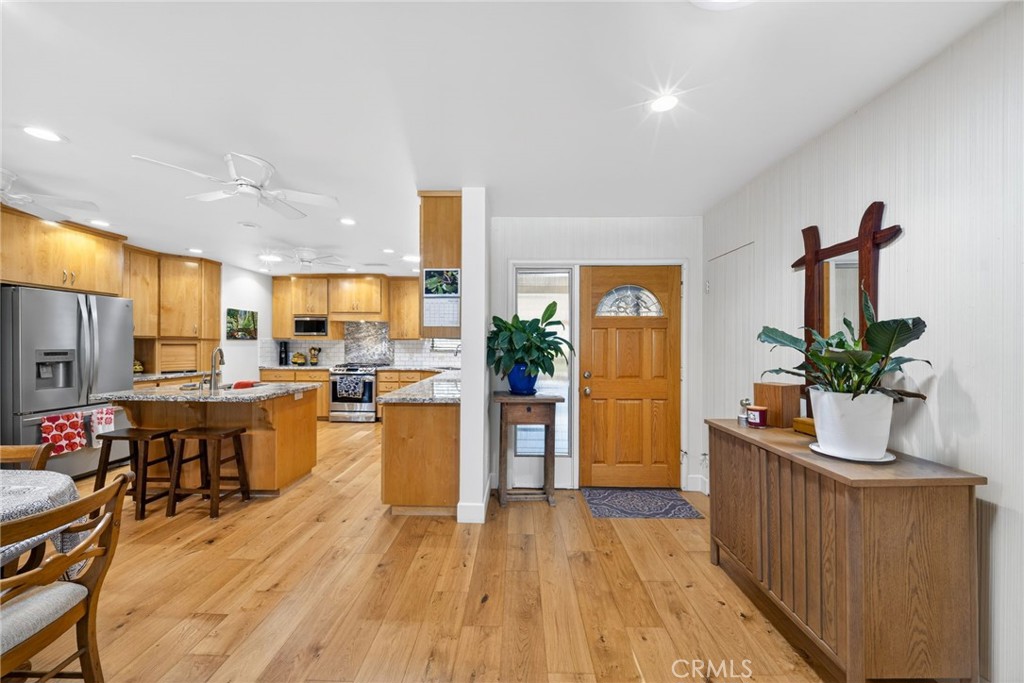 4872 N Arcade Fresno, CA 93704 - Photo 7 of 75 a kitchen with stainless steel appliances kitchen island granite countertop a refrigerator a stove top oven a dining table and chairs with wooden floor