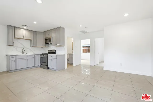 a large white kitchen with a sink and cabinets