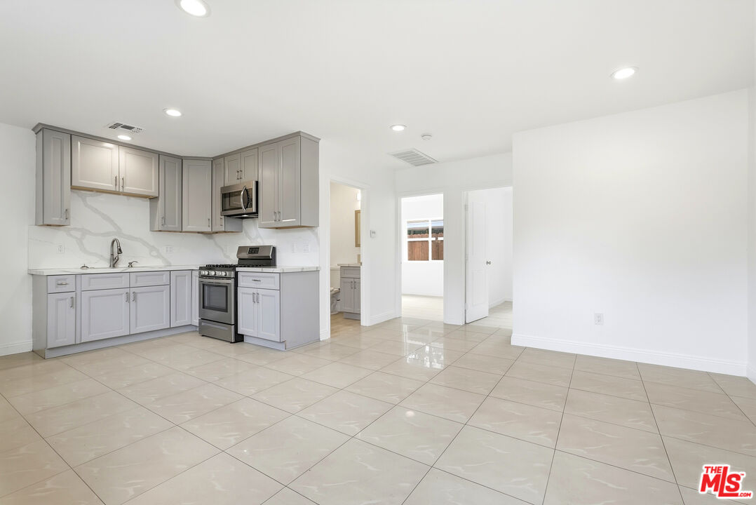 18149 Welby Way Reseda, CA 91335 - Photo 17 of 50 a large white kitchen with a sink and cabinets