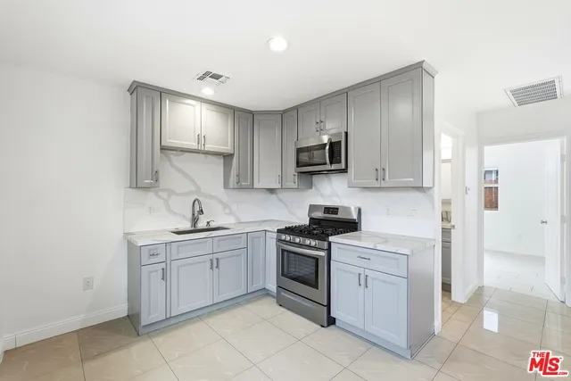 a kitchen with cabinets appliances and a sink