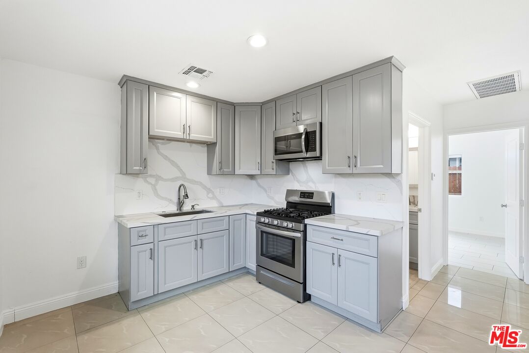 18149 Welby Way Reseda, CA 91335 - Photo 19 of 50 a kitchen with cabinets appliances and a sink