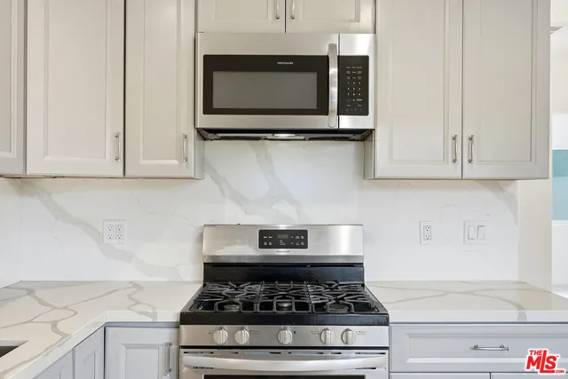 a stove top oven sitting inside of a kitchen