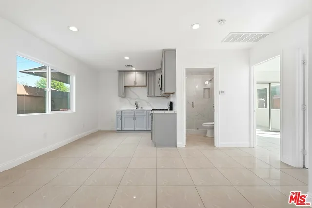 a view of a kitchen with refrigerator and windows