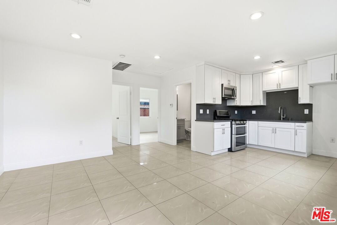 18149 Welby Way Reseda, CA 91335 - Photo 32 of 50 a kitchen with stainless steel appliances a refrigerator sink and cabinets