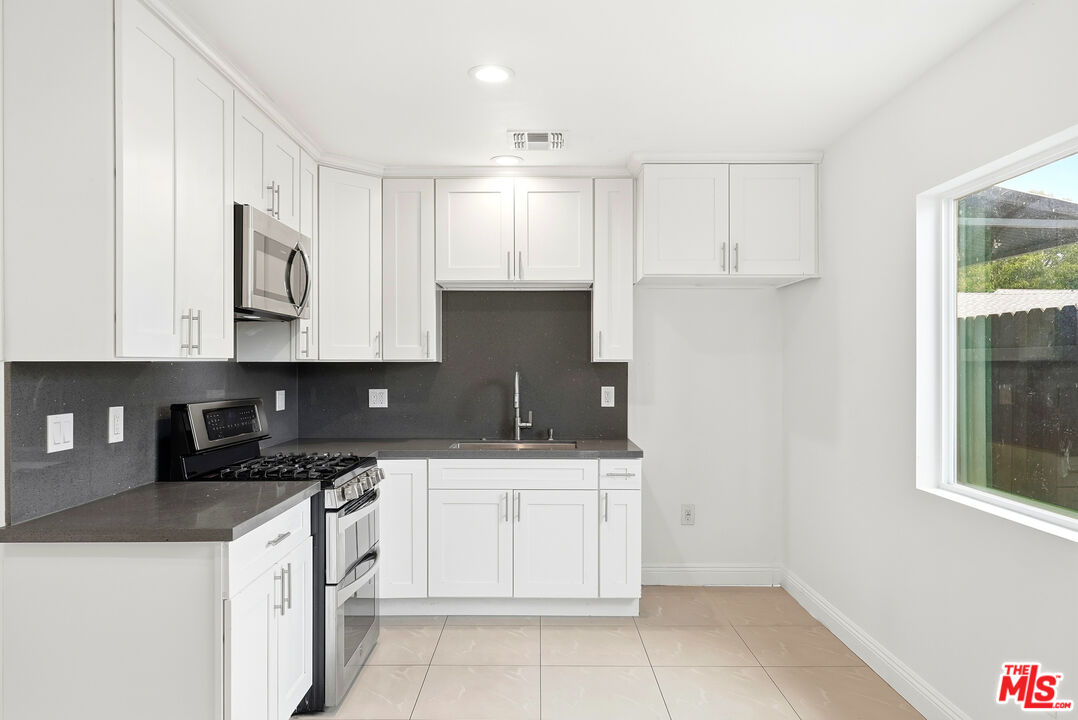 18149 Welby Way Reseda, CA 91335 - Photo 33 of 50 a kitchen with a sink stove and cabinets