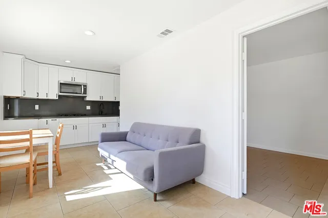 a living room with furniture and a kitchen view