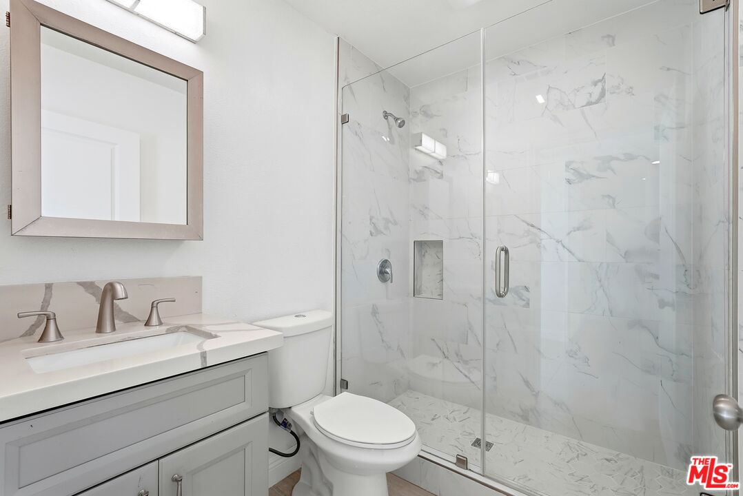 18149 Welby Way Reseda, CA 91335 - Photo 44 of 50 a bathroom with a sink toilet a mirror and shower