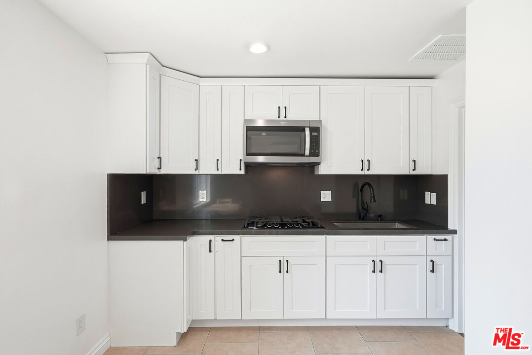 18149 Welby Way Reseda, CA 91335 - Photo 7 of 50 a kitchen with stainless steel appliances a microwave and cabinets