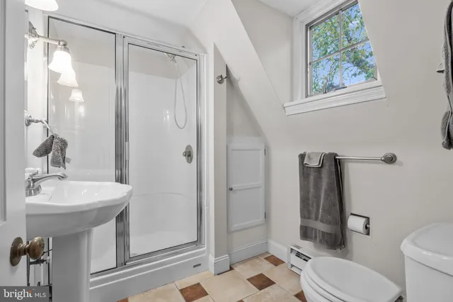 a spacious bedroom with a bed a ceiling fan and a dresser