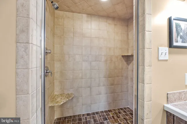 a view of patio with table and chairs and floor to ceiling window with wooden fence