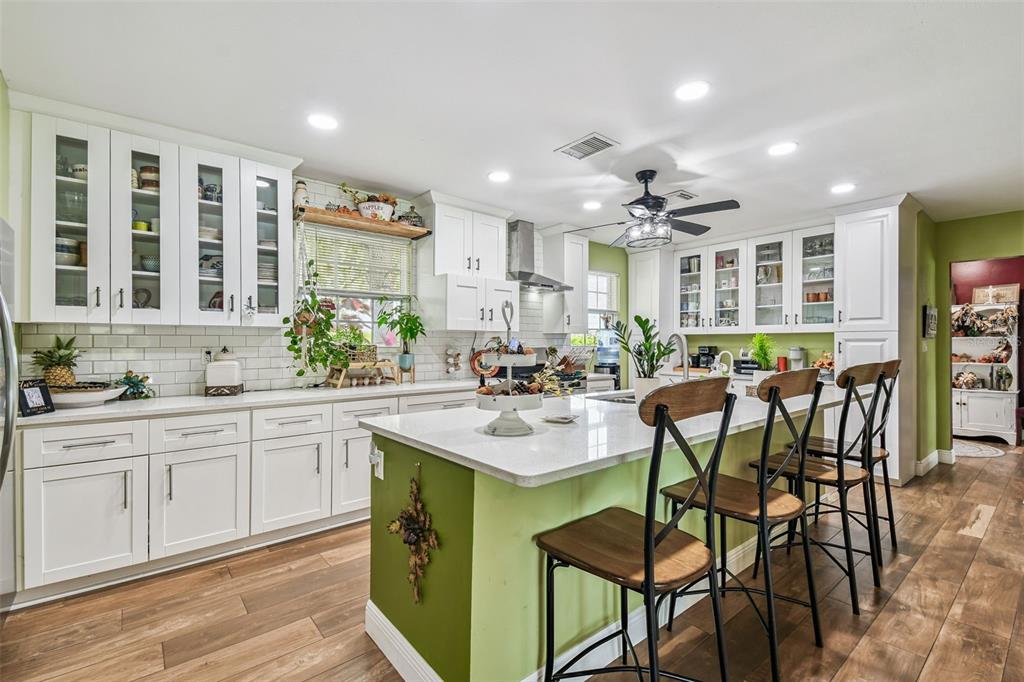 33937 St Benedict Road San Antonio, FL 33576 - Photo 16 of 58 a kitchen with a dining table chairs cabinets and stainless steel appliances
