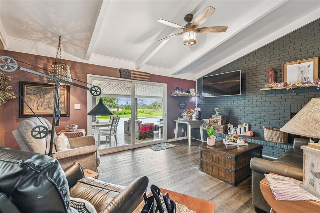 33937 St Benedict Road San Antonio, FL 33576 - Photo 19 of 58 a living room with furniture a fireplace and a flat screen tv