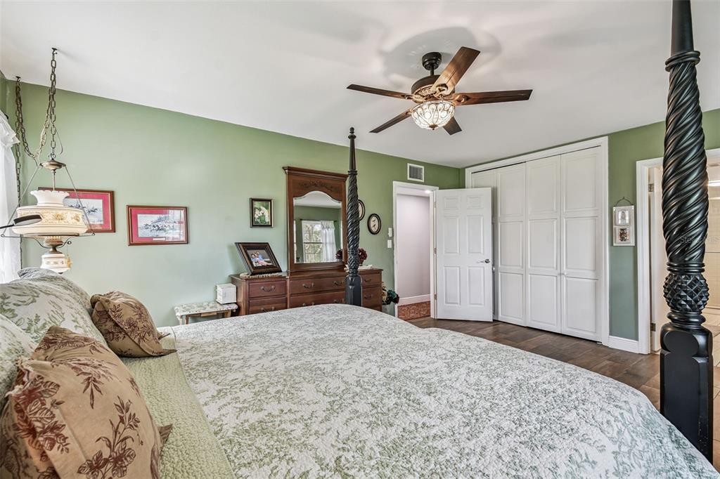 33937 St Benedict Road San Antonio, FL 33576 - Photo 27 of 58 a bedroom with a large bed and a chandelier