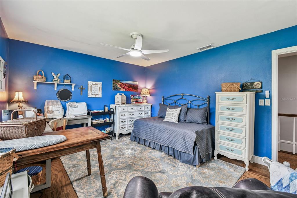 33937 St Benedict Road San Antonio, FL 33576 - Photo 36 of 58 a bedroom with a bed and a chandelier