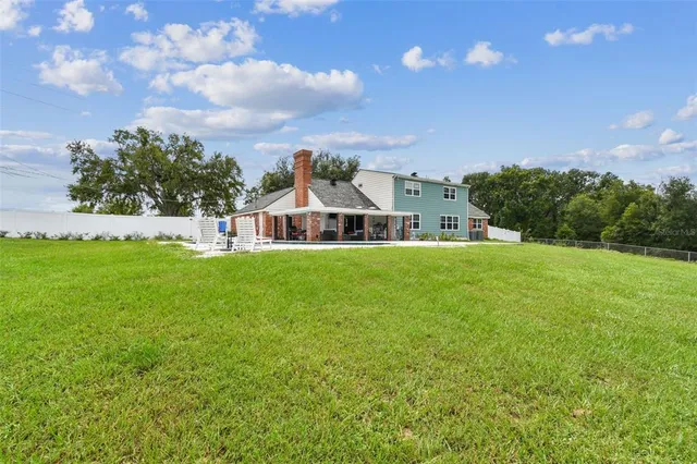 a view of swimming pool with lawn chairs and a fire pit