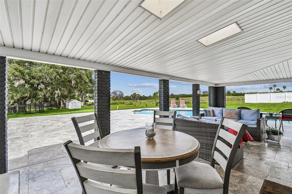 33937 St Benedict Road San Antonio, FL 33576 - Photo 52 of 58 a view of a patio with table and chairs and floor to ceiling window with wooden floor