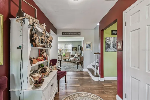 a view of a hallway with wooden floor and furniture