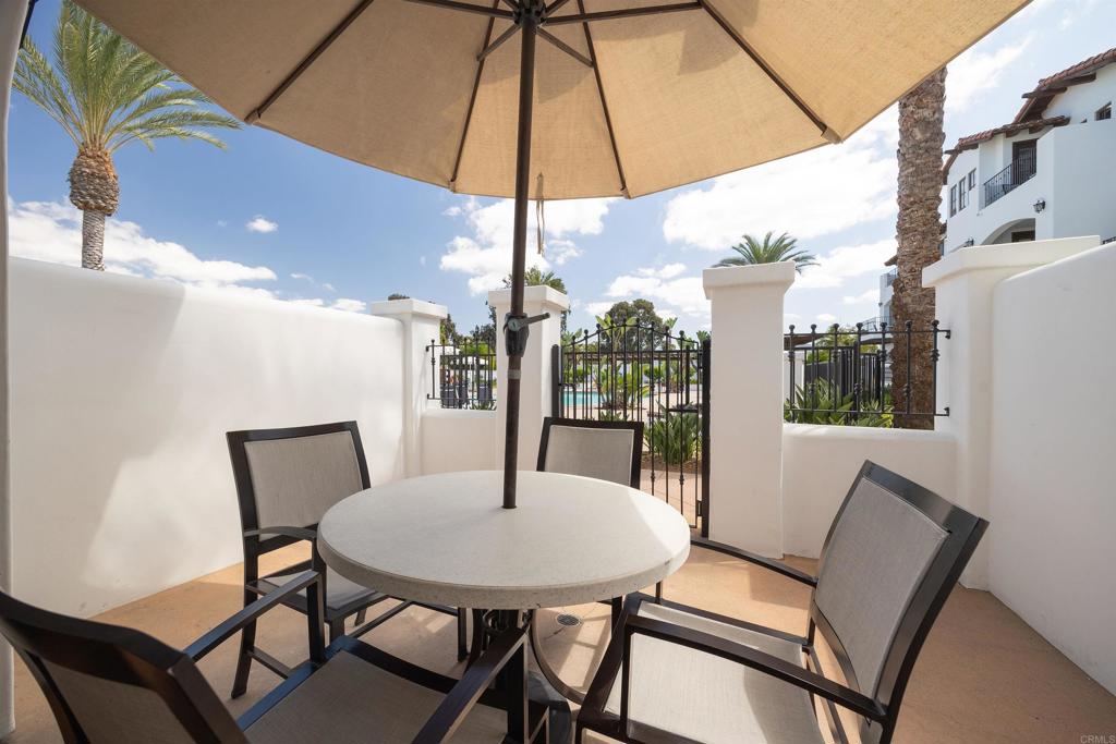 7310 Estrella De Mar Road, Unit 6 Carlsbad, CA 92009 - Photo 12 of 46 a view of a patio with a table and chairs under an umbrella