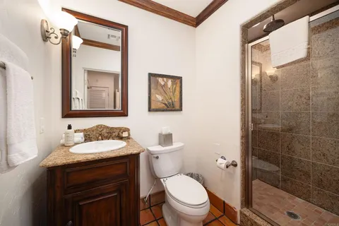 a bathroom with a toilet sink vanity and mirror