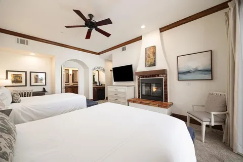 a bedroom with a large bed a flat screen tv and a fireplace