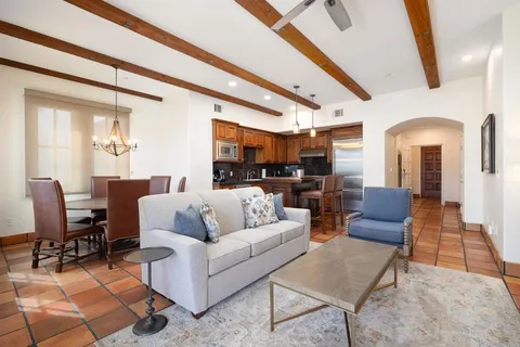 a living room with furniture wooden floor and a large window