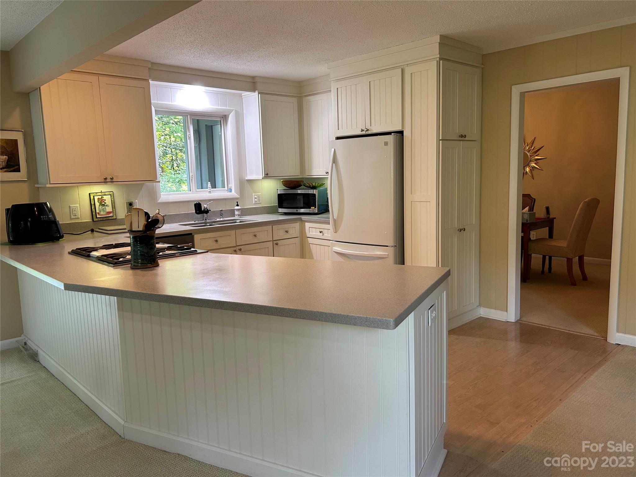 428 Brandon Road Hendersonville, NC 28739 - Photo 20 of 48 a kitchen with stainless steel appliances a sink a refrigerator and white cabinets
