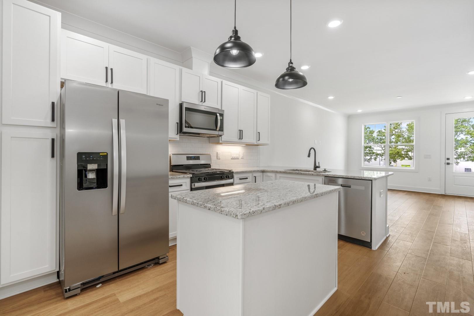 6108 Fox Road Raleigh, NC 27616 - Photo 13 of 40 a kitchen with stainless steel appliances granite countertop a refrigerator a stove a sink and a window