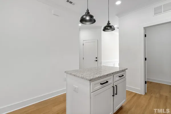 a kitchen with stainless steel appliances granite countertop white cabinets and wooden floor