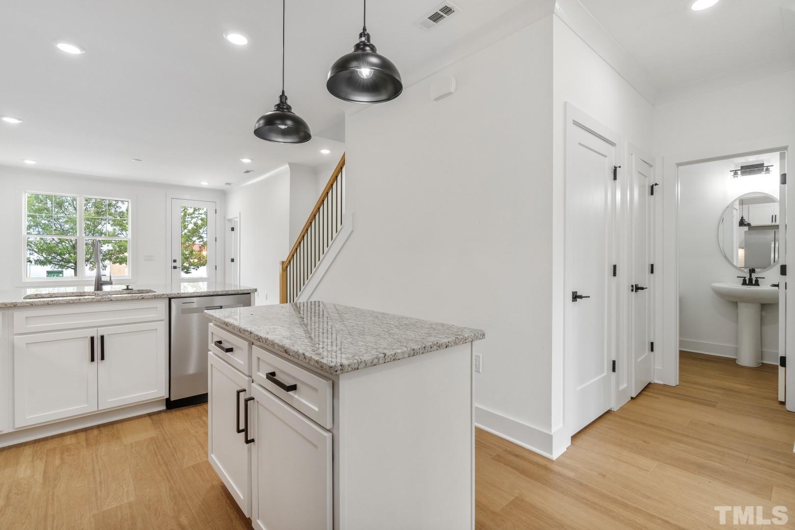 6108 Fox Road Raleigh, NC 27616 - Photo 20 of 40 a kitchen with white cabinets and wooden floor