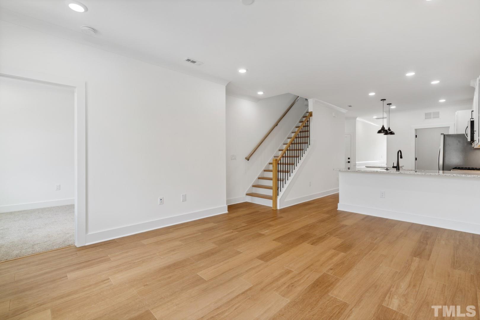 6108 Fox Road Raleigh, NC 27616 - Photo 21 of 40 a view of an empty room with wooden floor and stairs