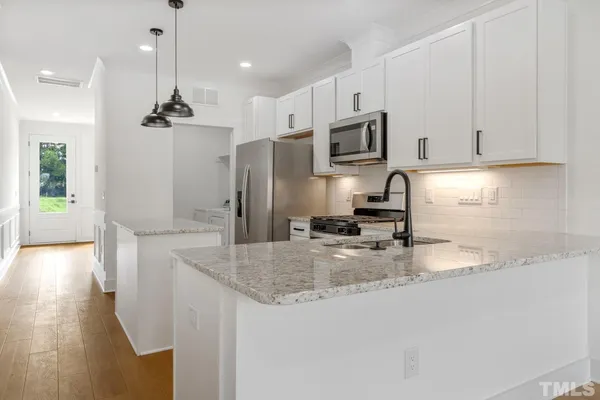 a kitchen with stainless steel appliances granite countertop a sink refrigerator and microwave