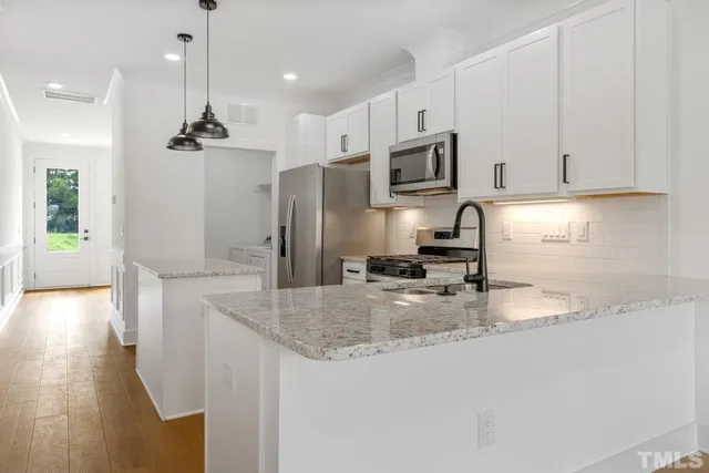 a kitchen with stainless steel appliances granite countertop a sink refrigerator and microwave