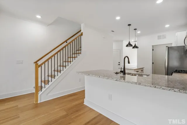 a kitchen with stainless steel appliances granite countertop a sink and a refrigerator