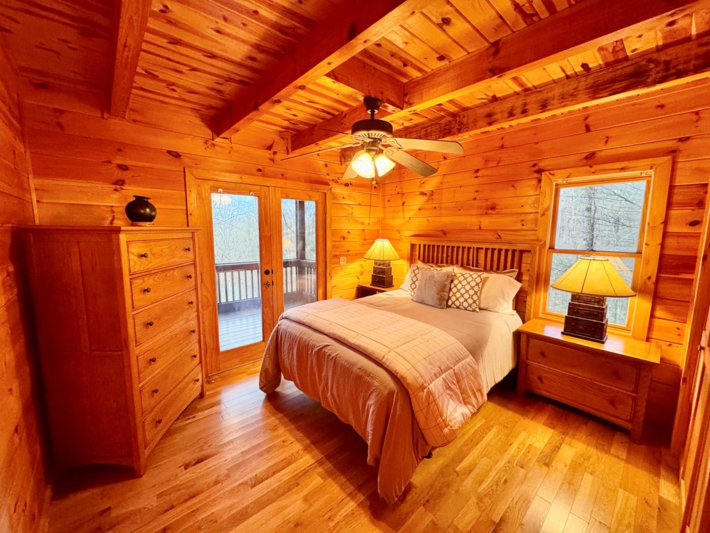 162 Toccoa Overlook Lane Blue Ridge, GA 30513 - Photo 22 of 39 a spacious bedroom with a bed and wooden floor
