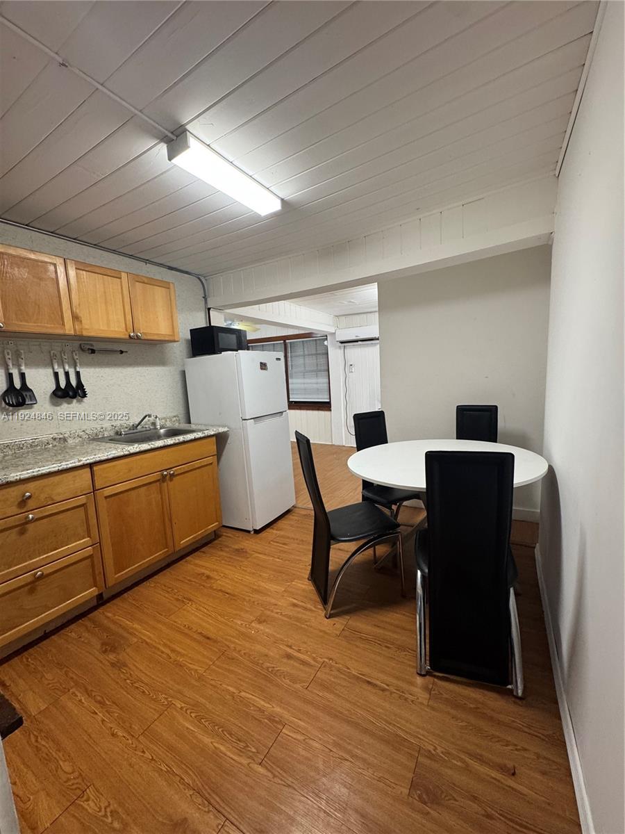 3271 (rear Studio) Nw 15th Street Miami, FL 33125 - Photo 5 of 11 a kitchen with a table chairs and wooden floor