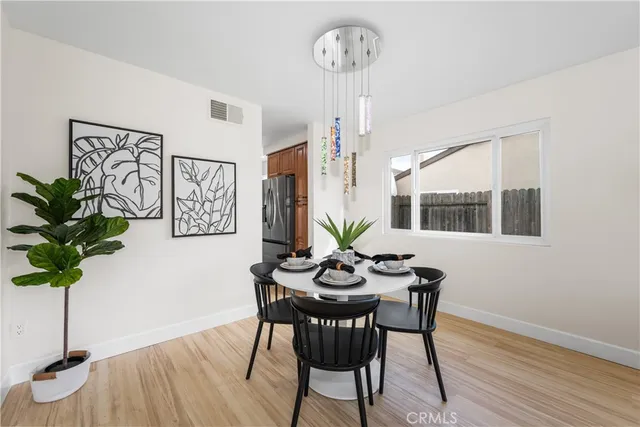 a dining room with furniture potted plants and wooden floor