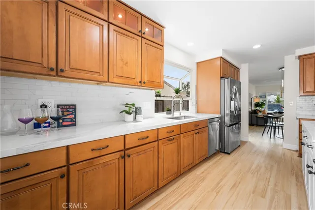 a kitchen with stainless steel appliances granite countertop a sink a stove cabinets and wooden floor