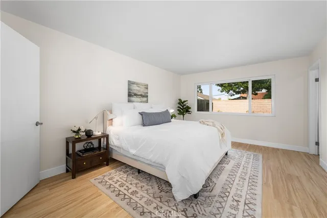 a bedroom with a bed and wooden floor