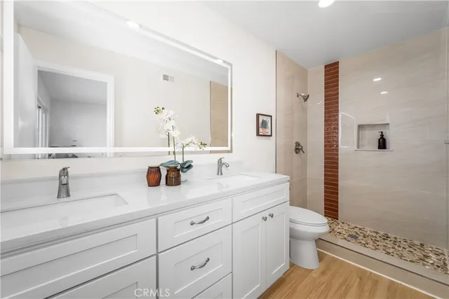 a bathroom with a double vanity sink toilet and shower