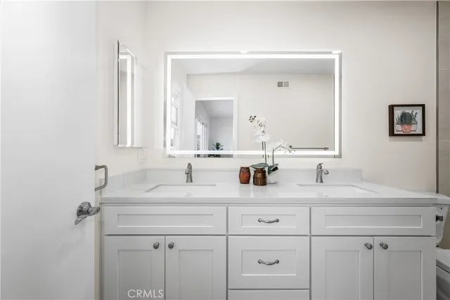 a bathroom with double sink and a mirror
