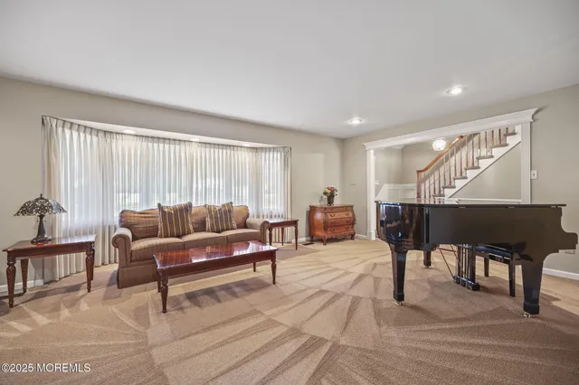 a living room with furniture a wooden floor and a large window