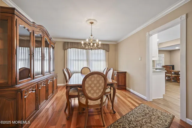 a dining room with furniture a chandelier and wooden floor