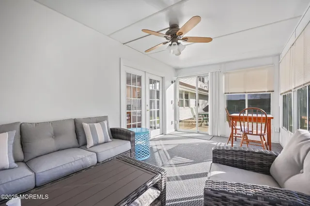 a living room with furniture a rug potted plant and a large window
