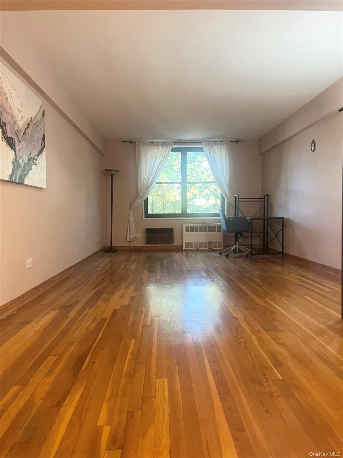 139-15 83rd Avenue, Unit 407 Queens, NY 11435 - Photo 2 of 8 wooden floor in an empty room with a window
