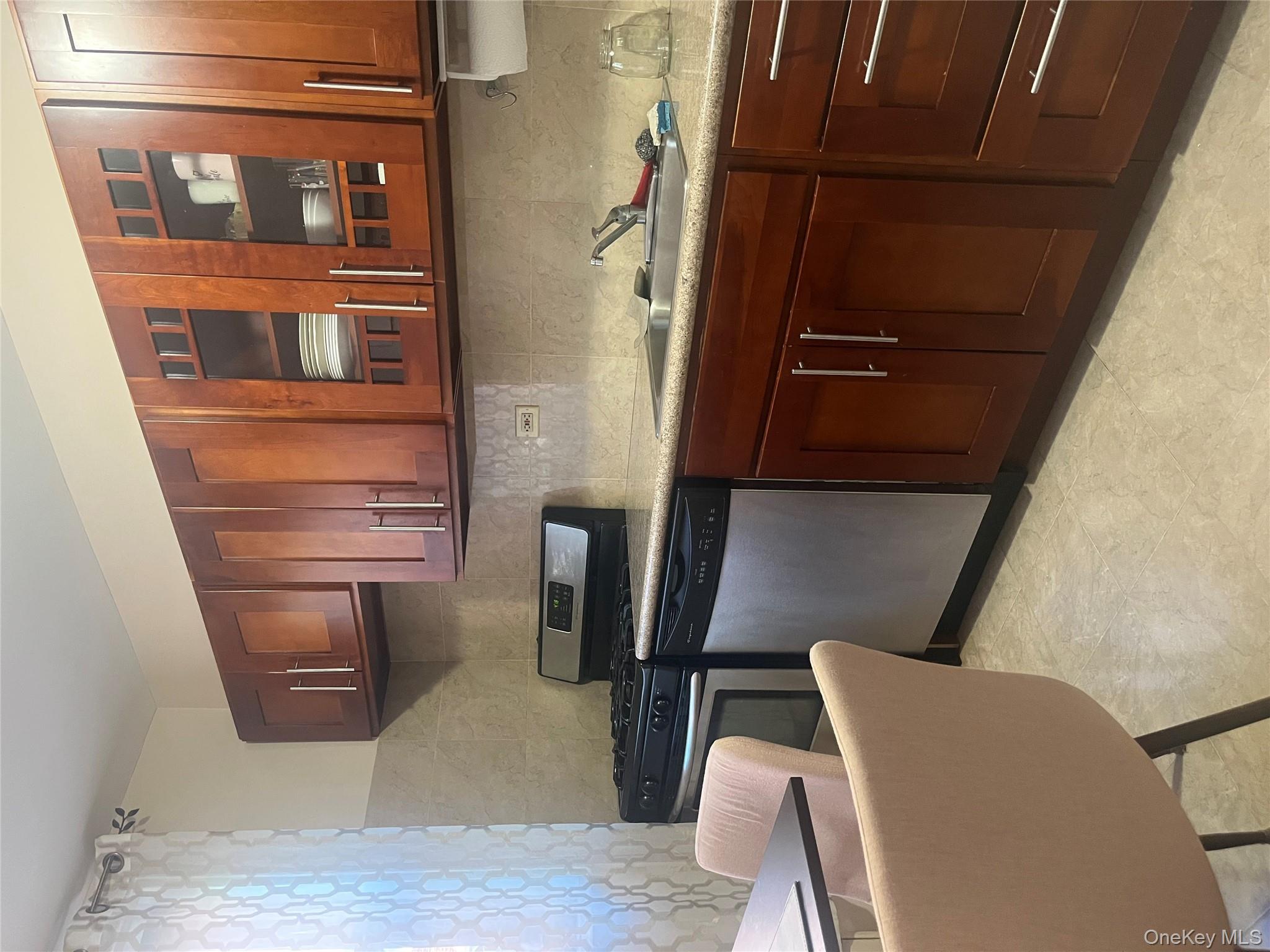 139-15 83rd Avenue, Unit 407 Queens, NY 11435 - Photo 4 of 8 a kitchen with stainless steel appliances granite countertop a sink dishwasher stove and cabinets