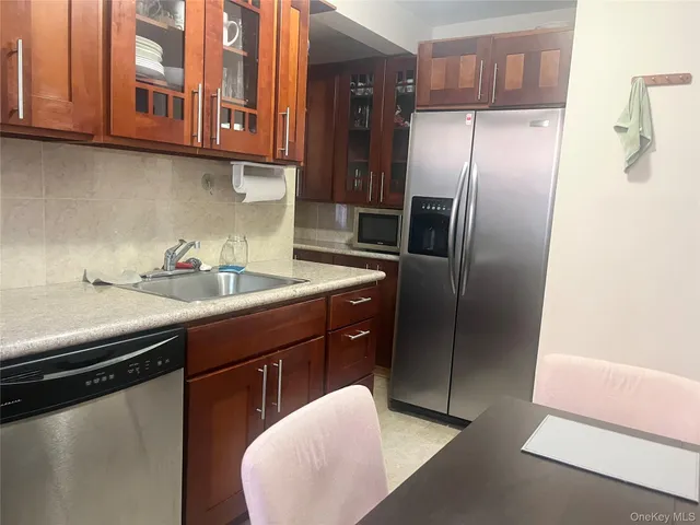 a kitchen with stainless steel appliances granite countertop a sink a refrigerator and a cabinets