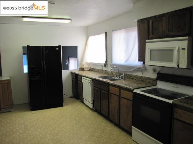 1943 South Ranchero Road Valley Springs, CA 95252 - Photo 11 of 23 Kitchen with black appliances and dark brown cabinets