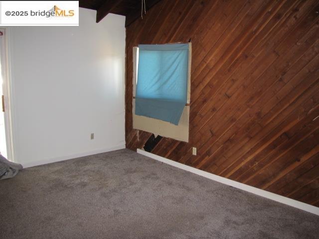 1943 South Ranchero Road Valley Springs, CA 95252 - Photo 14 of 23 Spare room with wood walls, carpet, and beam ceiling