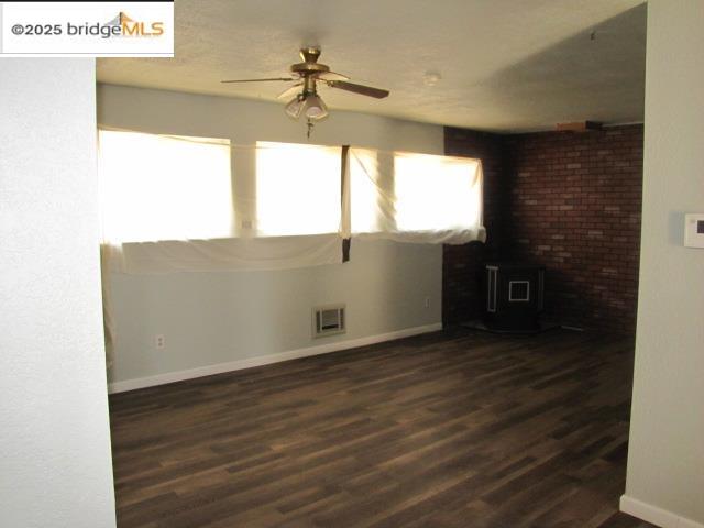 1943 South Ranchero Road Valley Springs, CA 95252 - Photo 18 of 23 Unfurnished living room with a wood stove, a ceiling fan, and dark wood-type flooring